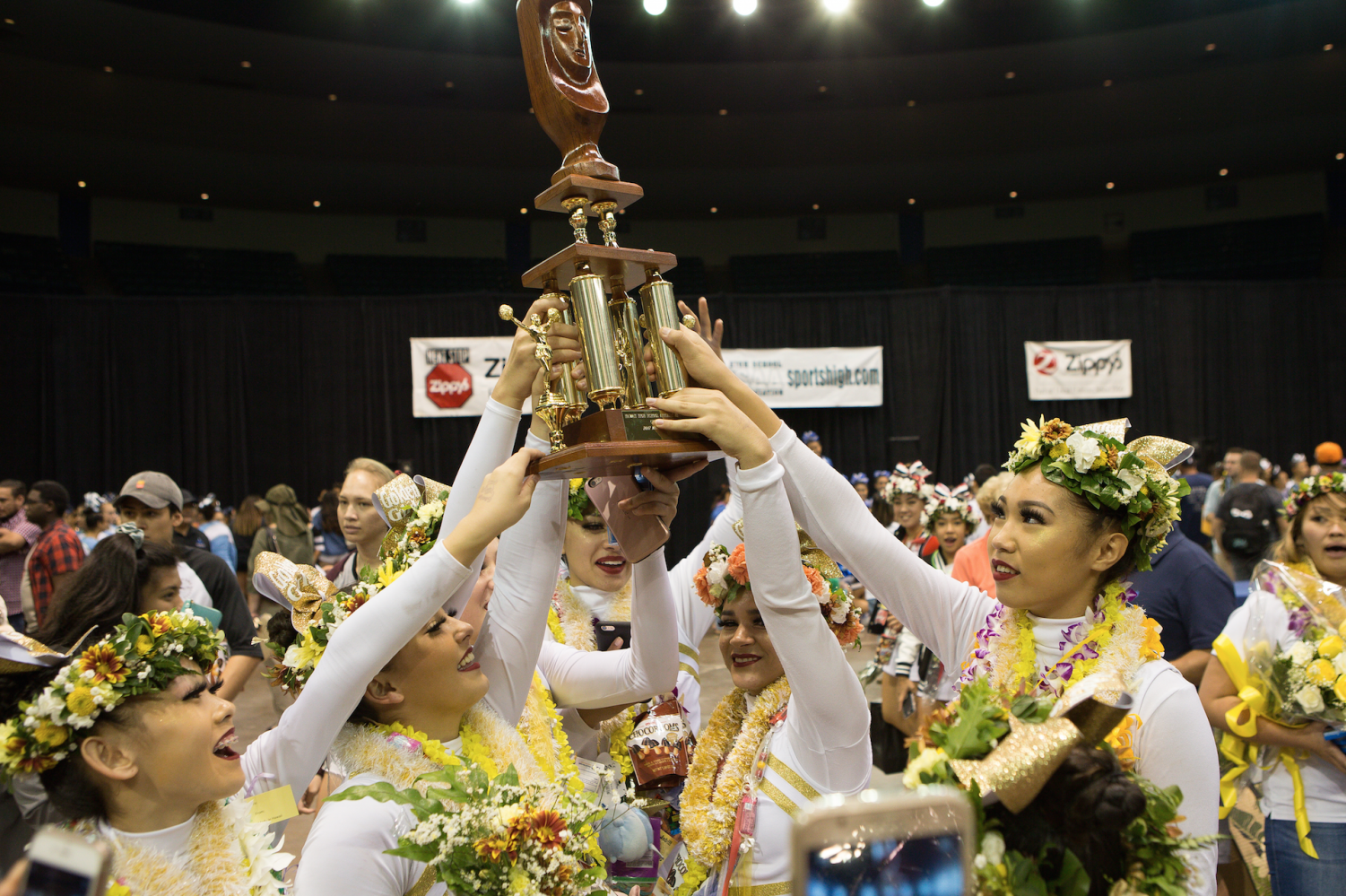 The Academy’s varsity cheerleading team, also known as the Golden Girls, hold their trophy after winning first in the medium division. Photo courtesy of 808 Hot Shots.