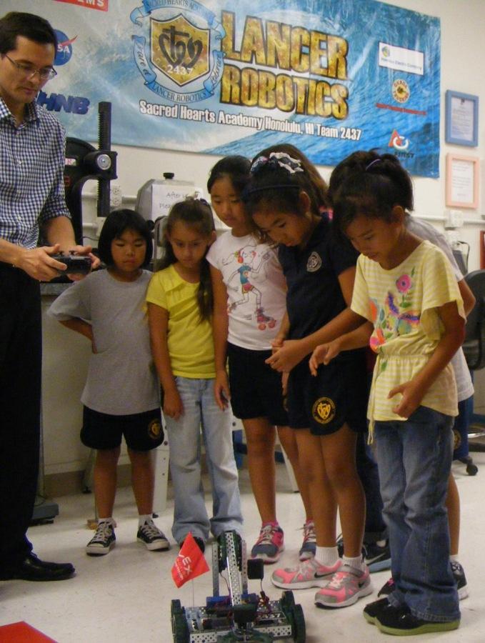 Robotics teacher Peter Park demonstrates a VEX robot to third graders. Park earned his certification as a VEX teacher during the summer at Carnegie Mellon University.