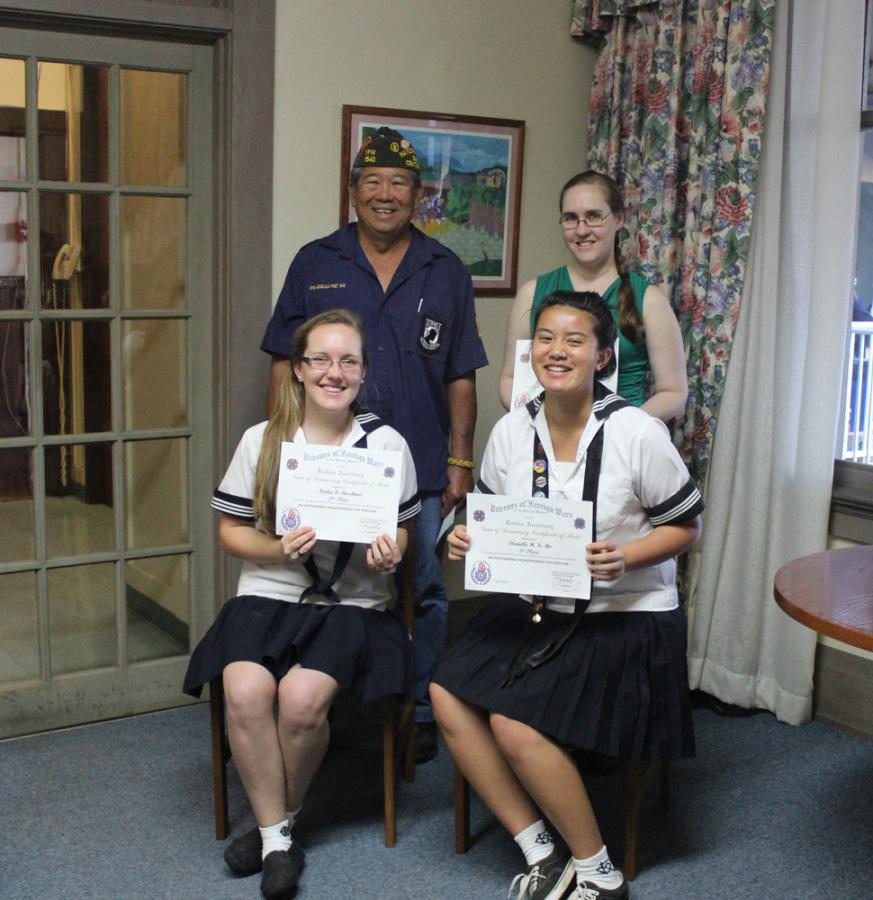 Seniors Nadia Busekrus and Danielle Ho display their certificates after winning second and first place in the Voice of Democracy essay contest, presented by Nick Young and English chair, Jill Sprott.