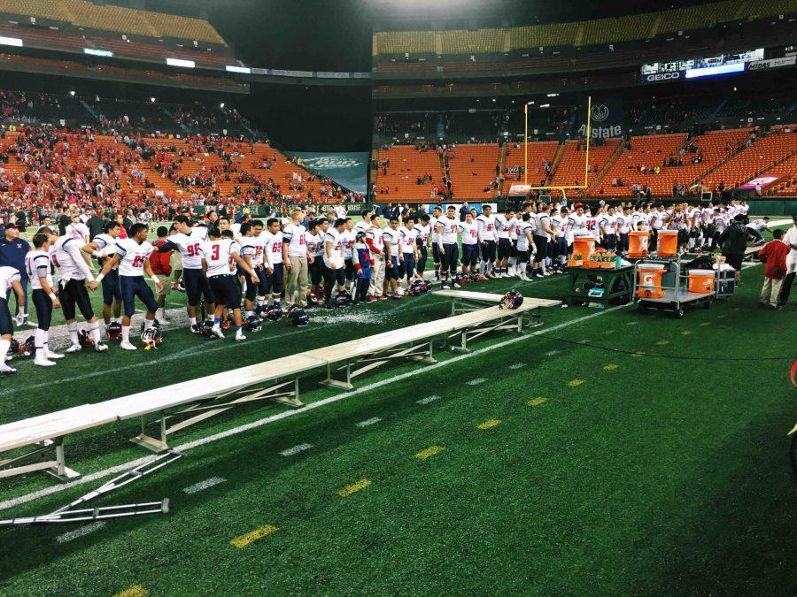 After receiving the state championship trophy, the Saint Louis football team sings the schools alma mater to family and friends at Aloha Stadium. Photo by Kekaimalie Woods.
