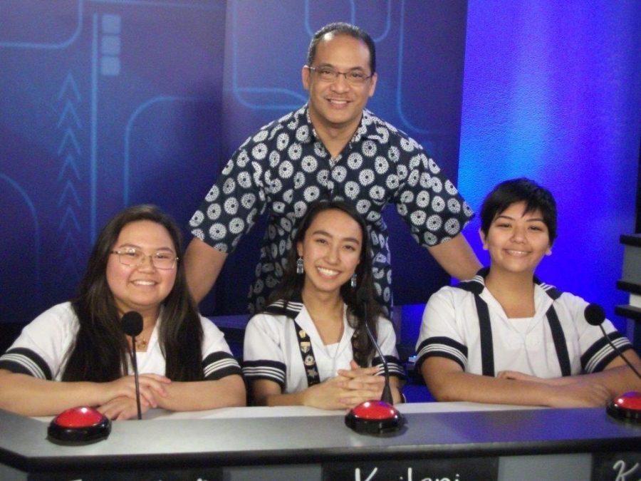 A great filming session is never complete without a photo. Seniors Janelle Lauronal, Kailanianna Ablog and junior Katherine Christian are all smiles with “It’s Academic Hawaii” host and Hawaii News Now reporter Billy V.  Photo courtesy of Lurline Choy.