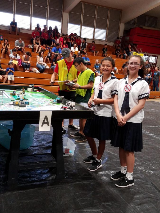 Members of the lower school First Lego League (FLL) robotics team working on their robot during the Kalani District Tournament. Photo courtesy of Jennifer Arthur.