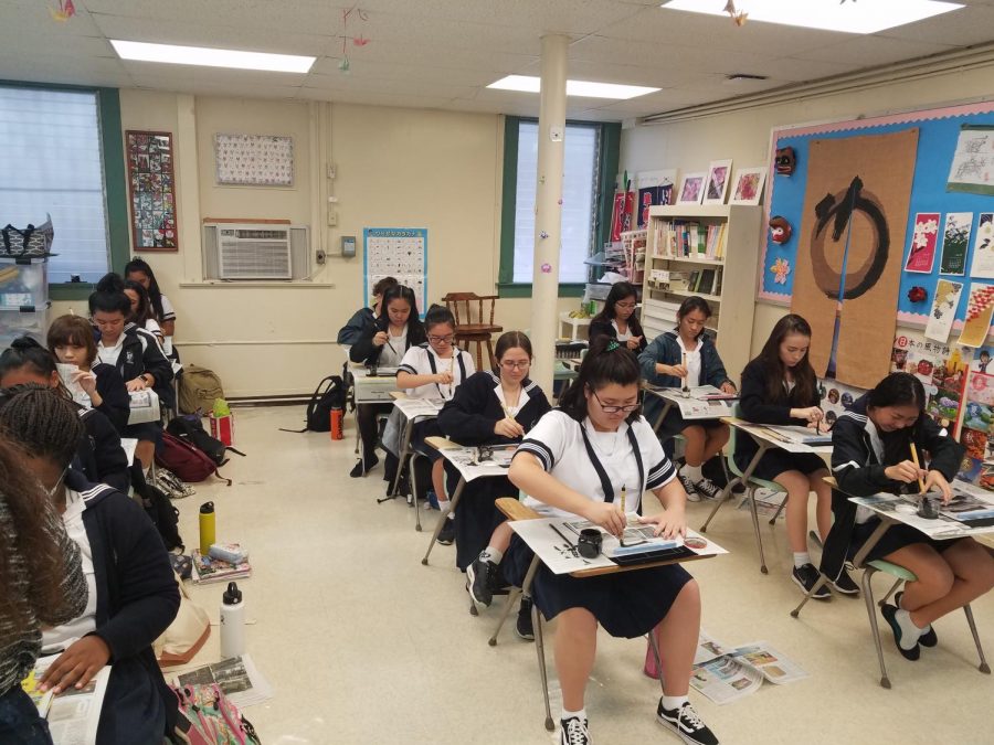 The Japanese III Honors class practices their kanji, a type of Japanese characters, on newspaper before using washi paper. Photos by Rebecca Meyer.