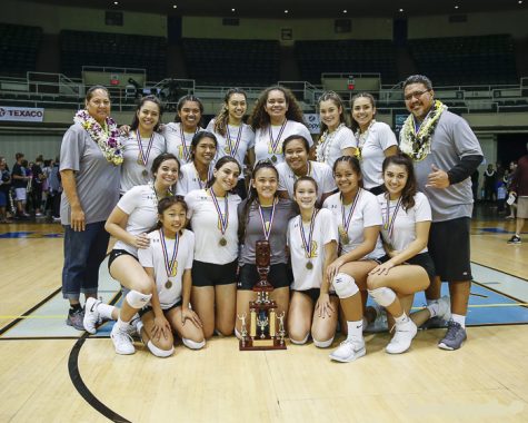 The varsity volleyball team after the game with the division II championship trophy. The Lancers beat two-time defending champion Le Jardin Academy.