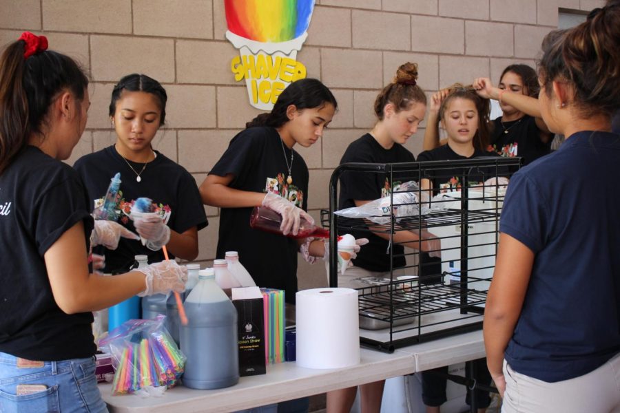 Shaved ice, a chilly treat with colorful syrups are handed out to each of the students and faculty touring the club fair, courtesy of this years student council at the front of the student center. 