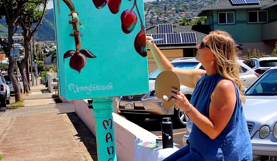 Artist Jenny Floro paints a mural on a traffic signal box in Kaimuki; it’s one of 26 boxes that got makeovers as part of a project coordinated by Street Art Hawaii. Photo by Kirsten Aoyagi.