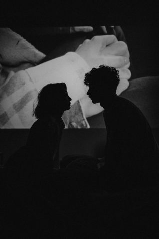 Photo of a couple in a movie theater, looking in love. Spending time together can help build connections. Photo courtesy of Pexels.