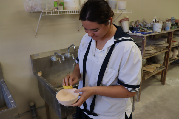 Senior Sara Kea smooths out the rim of her bowl before it is fired and glazed. Her pieces were donated to the Empty Bowl Project, which raised money for local food banks.