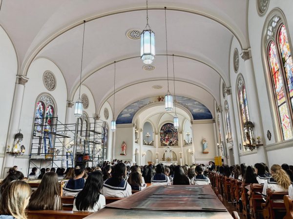 Students fill the of Sacred Hearts Academy’s Chapel during adoration and signing practice last month, surrounded by scaffolds and painting materials. 