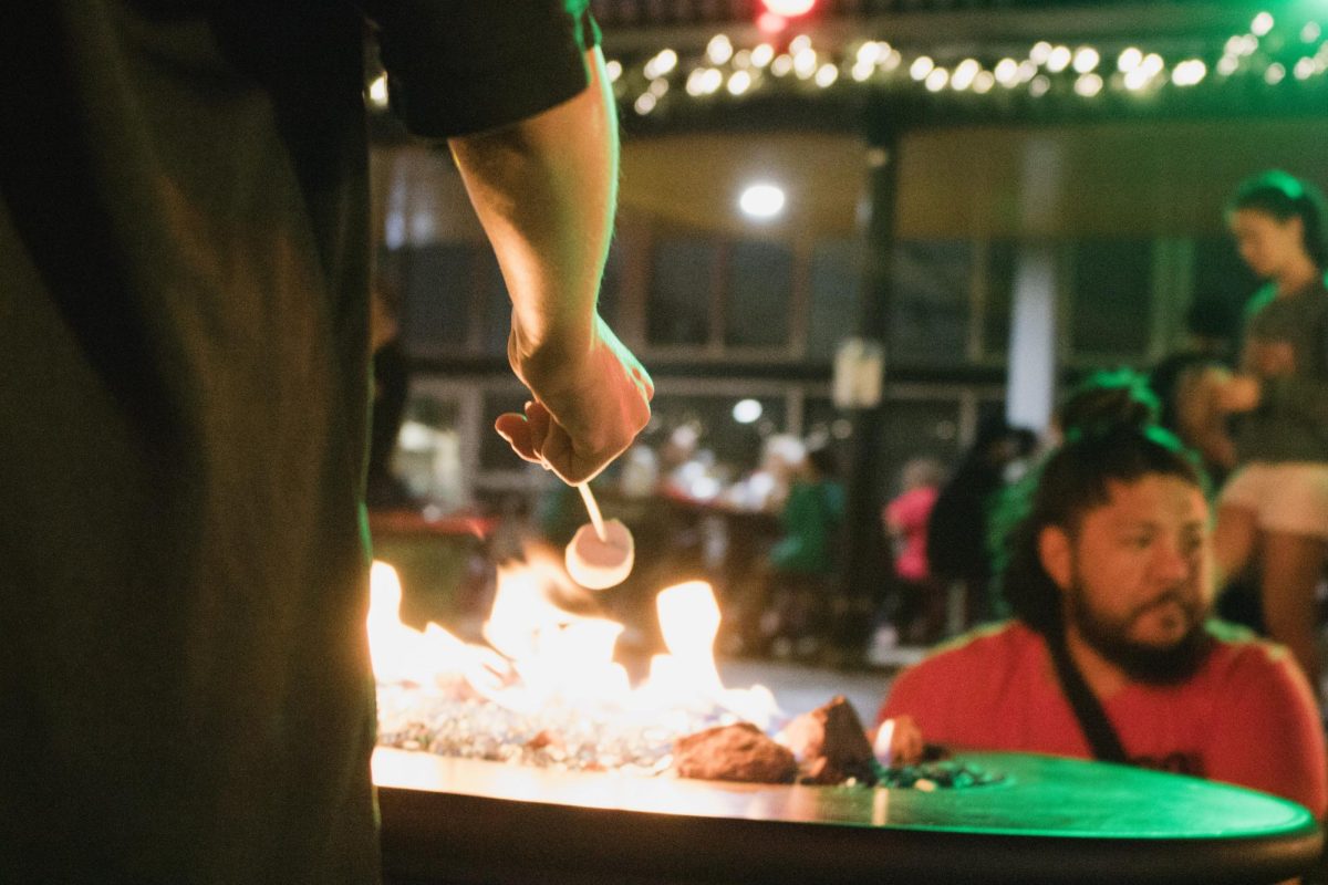 A marshmallow roasted over the fire at the s’mores pit as guests gathered nearby, taking in the warmth. The s’mores station was one of several activities offered, providing attendees with a place to relax during the event.