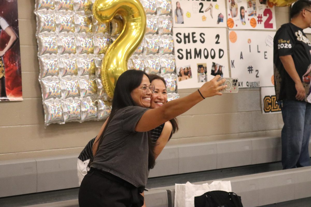 Parents share a moment while preparing decorations for senior night, helping create a memorable celebration for their daughters.